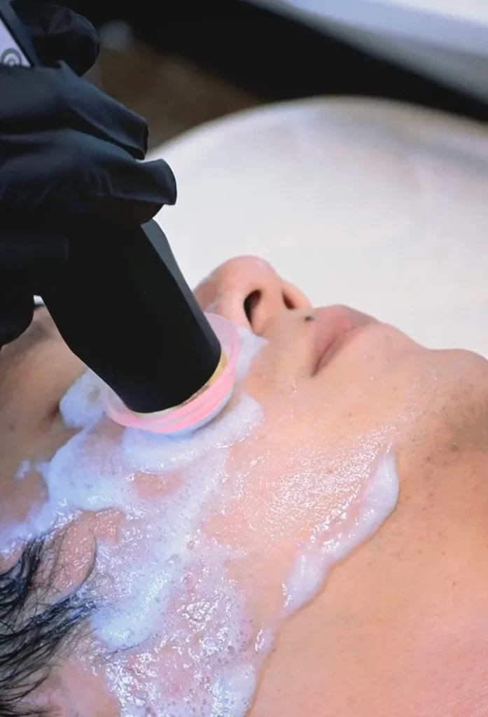 Appareil oxygène visage professionnel, esthéticienne réalise un soin nettoyant profond à l'oxygène sur une cliente en institut de beauté