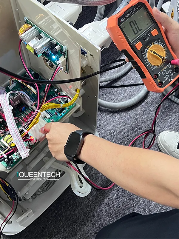 Technician uses multimeter to test internal fuselage circuit board of Lymphatic Roller Machine for safety pre-shipment inspection