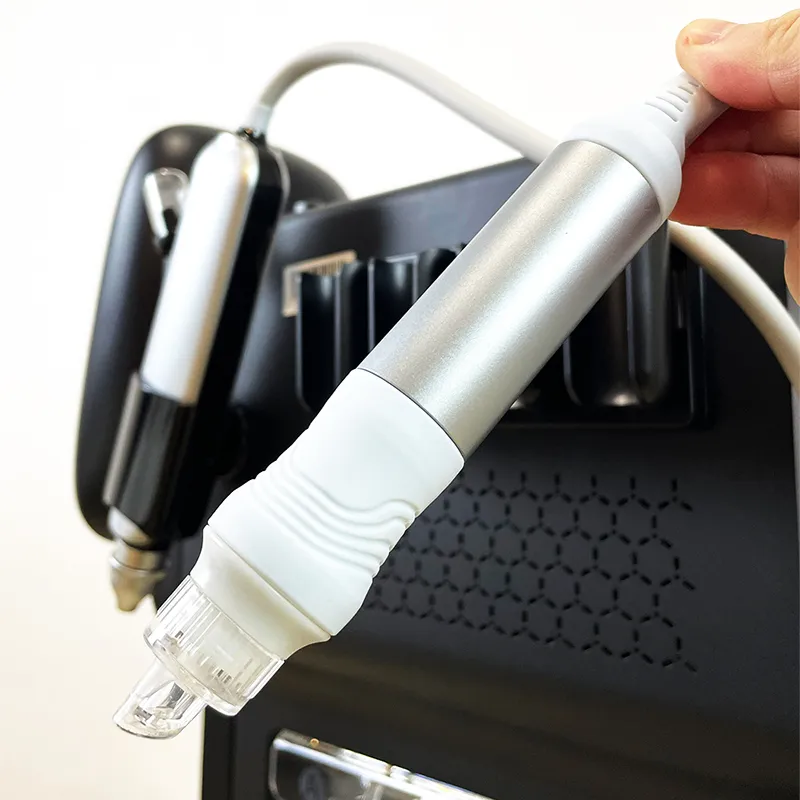 Main posant la poignée principale de l'appareil hydro dermabrasion sur le support, étape d'assemblage du soin exfoliant pour institut de beauté