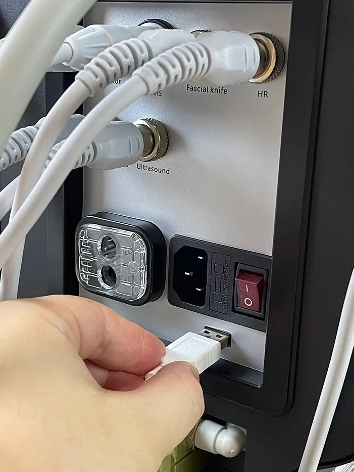Hand plugging signal connector of skin analysis handpiece into rear port of 10 in 1 hydradermabrasion machine, wiring connection installation step for diagnostic facial spa equipment