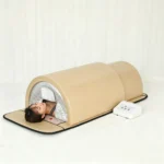 User receiving full body wellness treatment inside infrared sauna dome with separate temperature control panel